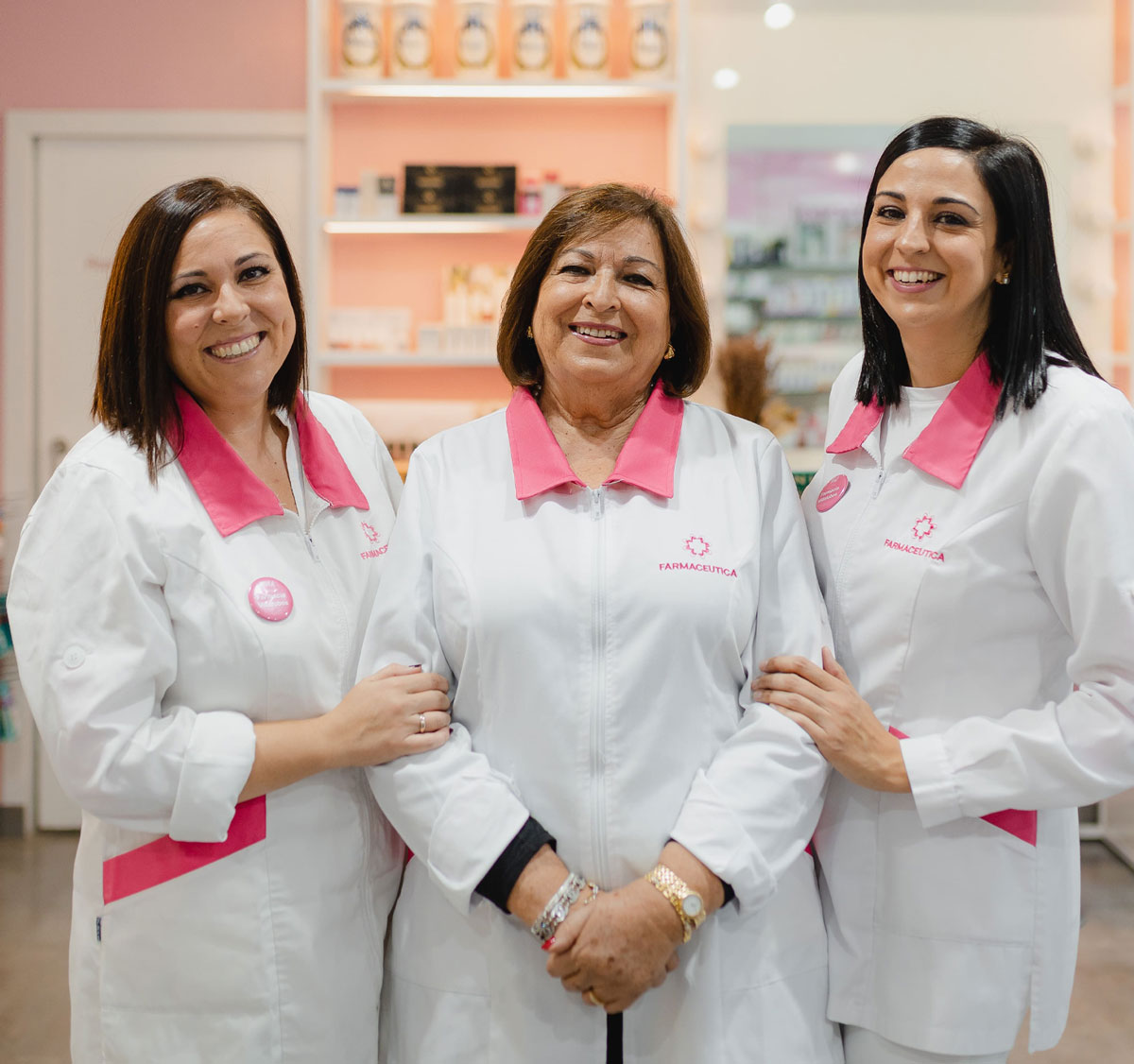 En la foto se ven 3 farmacéuticas sonriendo y uniformades